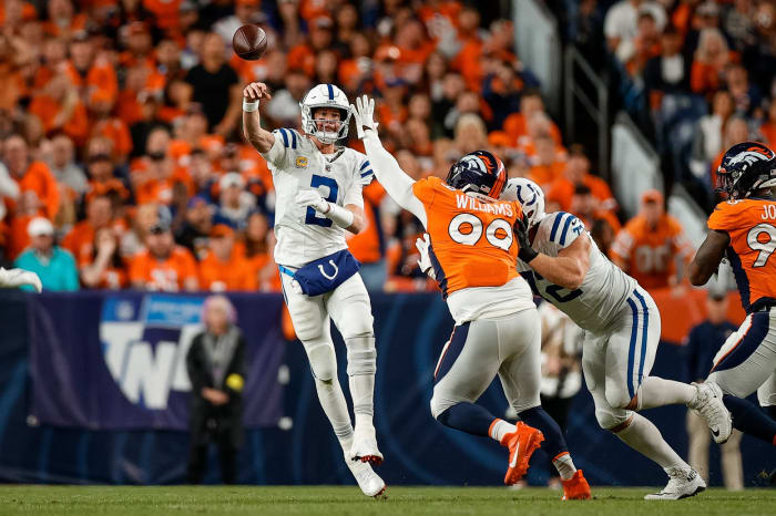 Indianapolis Colts quarterback Matt Ryan (2) passes under pressure from Denver Broncos defensive tackle DeShawn Williams (99) as offensive tackle Braden Smith (72) defends in the first quarter at Empower Field at Mile High.